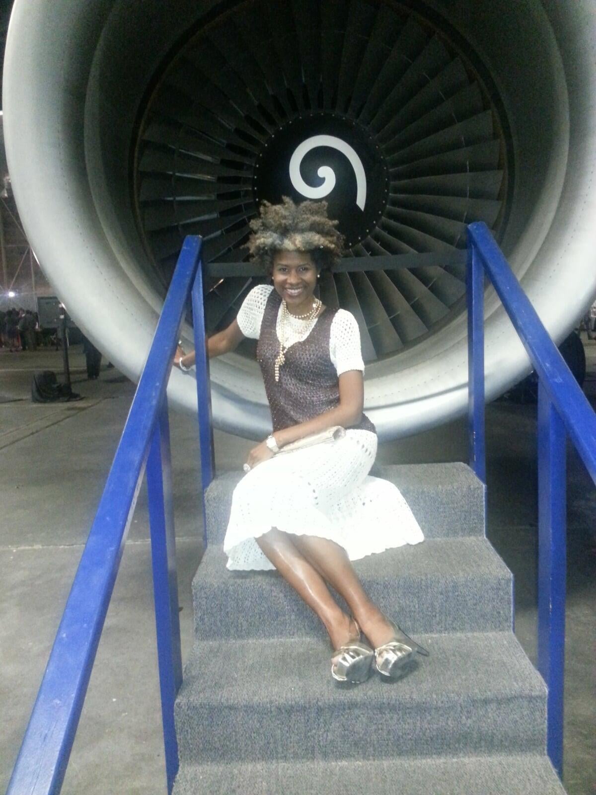 Andrea sitting in front of plane engine.